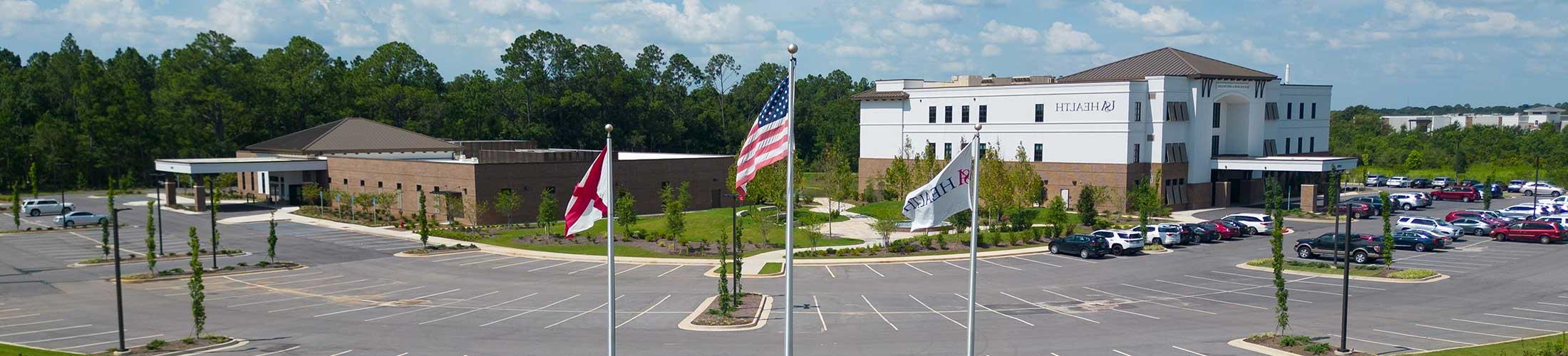 美国健康 facility with flags in front.